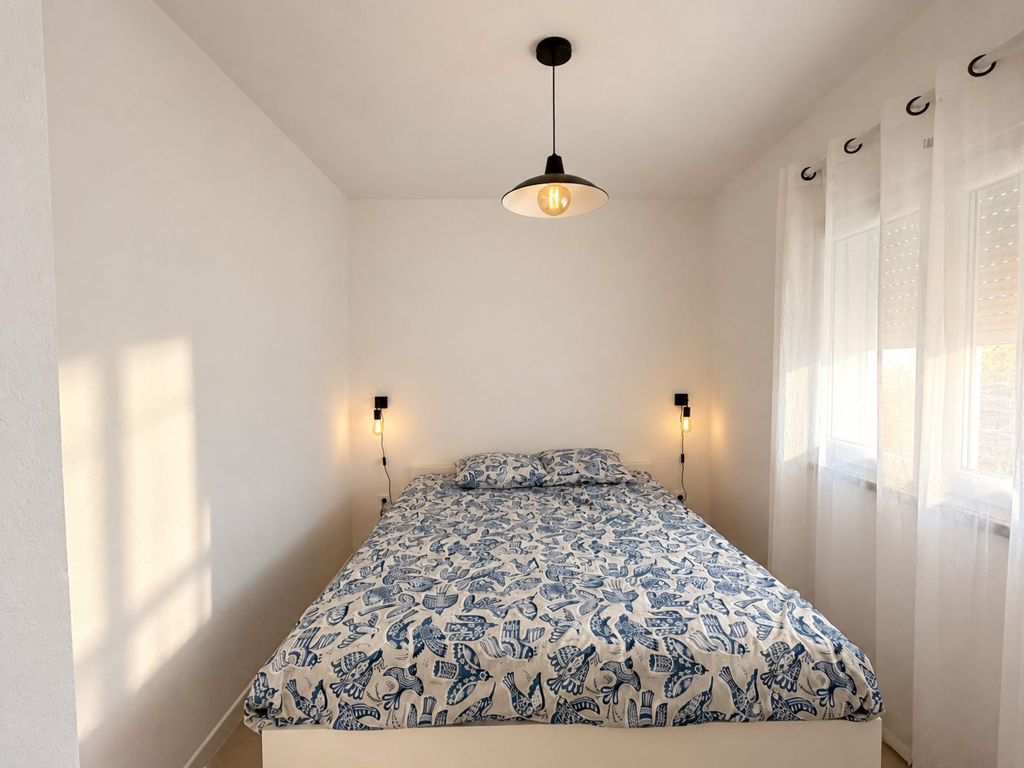 Bedroom with a blue bird-print bedspread